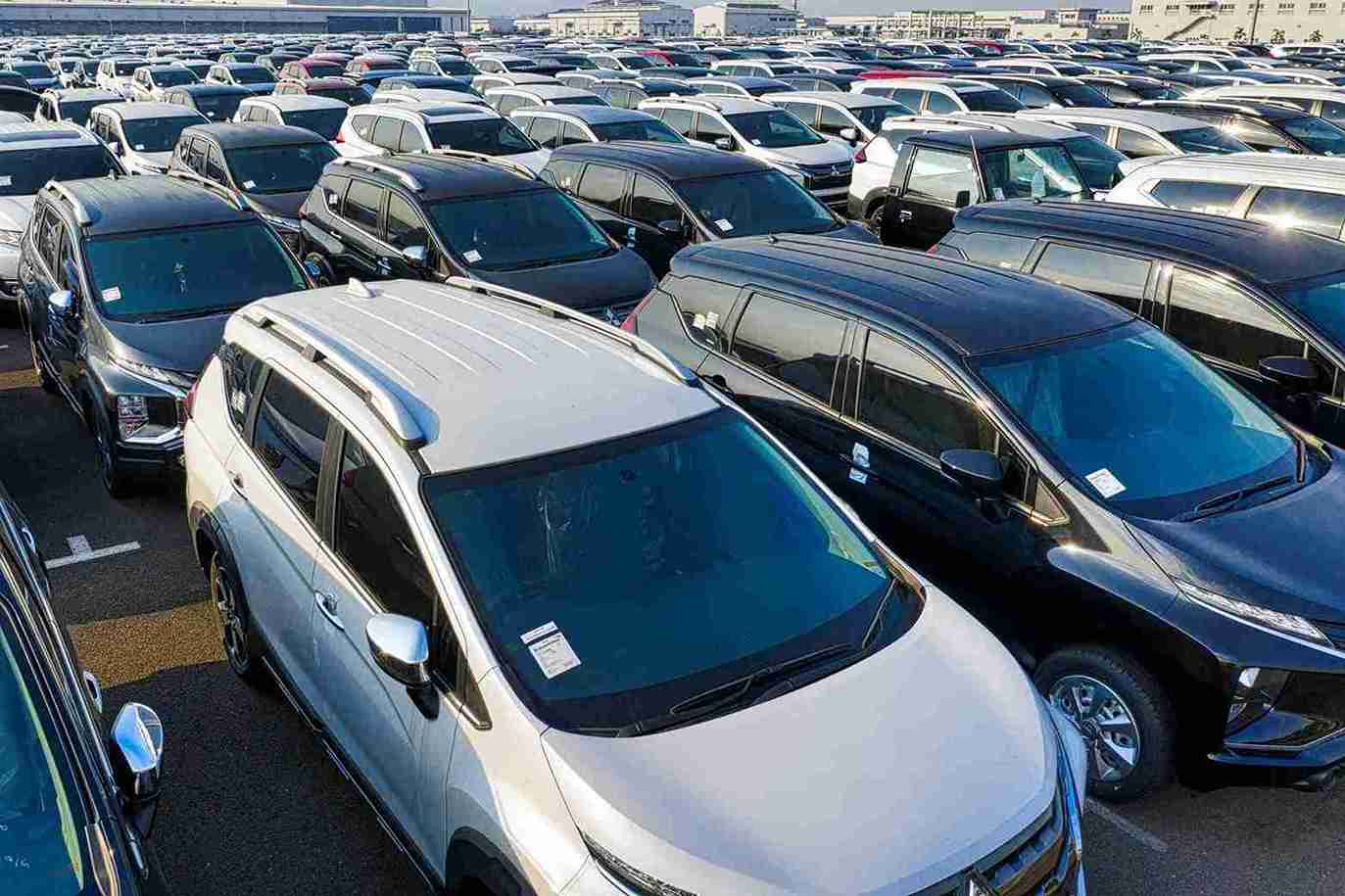 Vehículos Coches Almacén de vehículos nuevos-min_2 G2 Auto vehículos ocasión - Gran lote de vehículos nuevos estacionados en un almacén al aire libre listos para distribución.